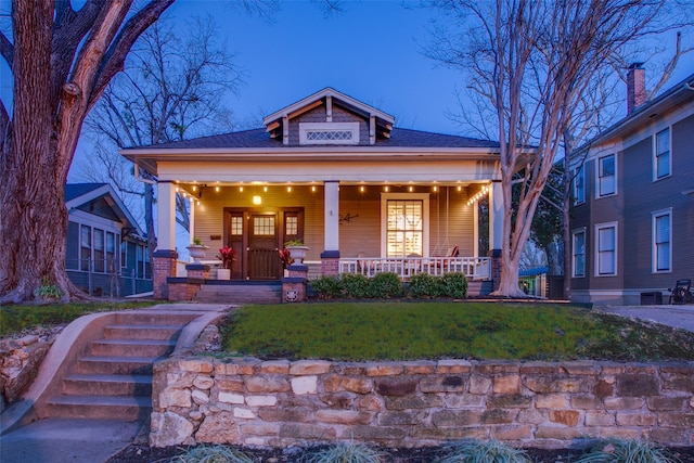 view of front of house with a porch and a shingled roof