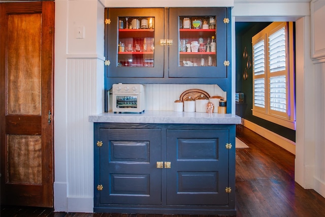 bar with dark wood finished floors and baseboards