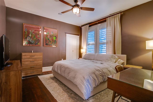 bedroom featuring a ceiling fan, wood finished floors, and baseboards