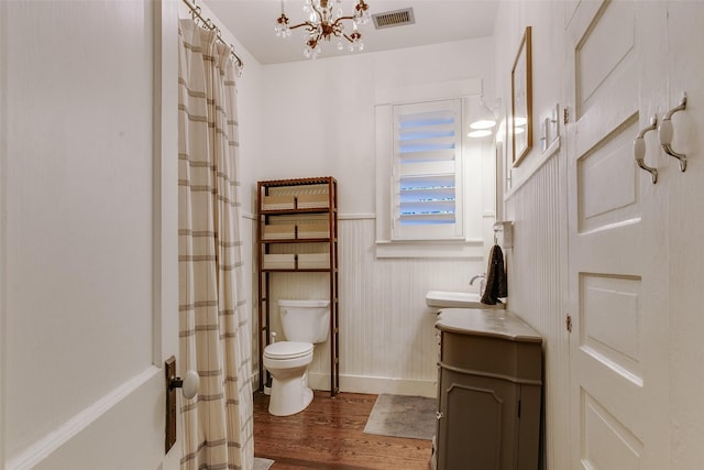 full bath with visible vents, a wainscoted wall, toilet, wood finished floors, and vanity