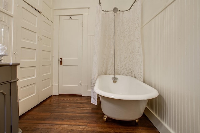 bathroom with vanity, a shower with shower curtain, wood finished floors, and a freestanding bath