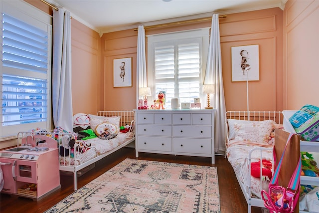 bedroom featuring a decorative wall and dark wood-style flooring