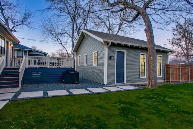 exterior space featuring a lawn, a wooden deck, and fence