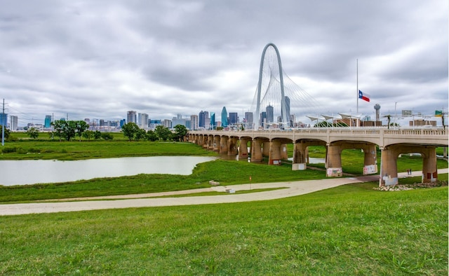 surrounding community with a view of city, a yard, and a water view