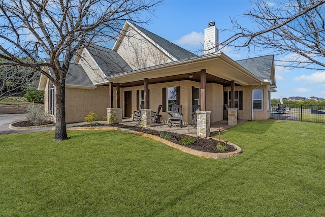 exterior space featuring a front yard, fence, brick siding, and a chimney