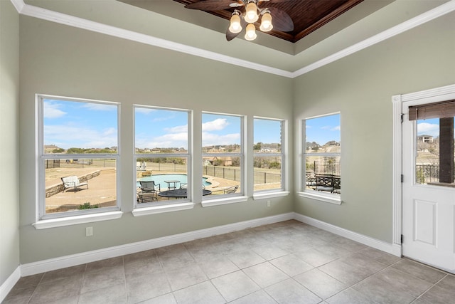 unfurnished sunroom featuring a tray ceiling and a ceiling fan