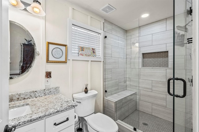 full bathroom with vanity, toilet, visible vents, and a stall shower