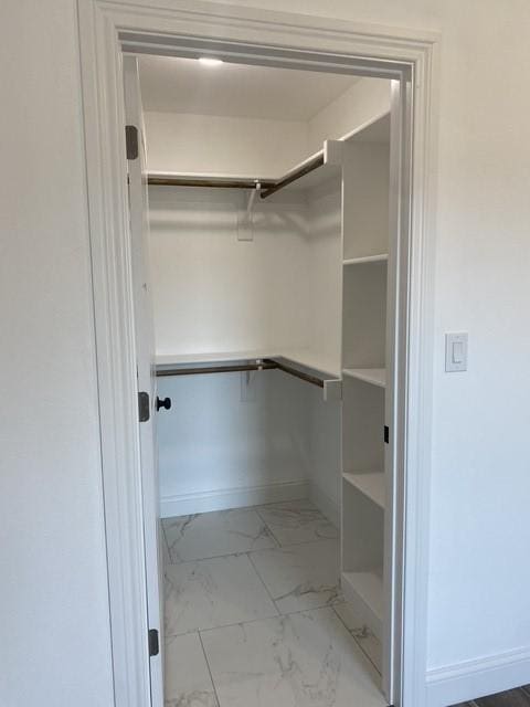 walk in closet with marble finish floor