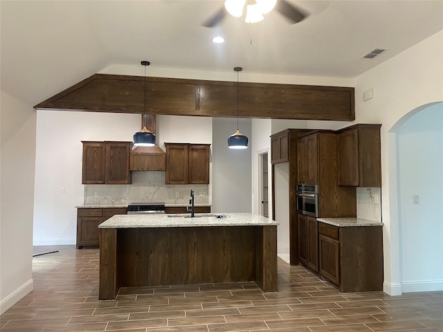 kitchen featuring decorative backsplash, wood tiled floor, a sink, oven, and range