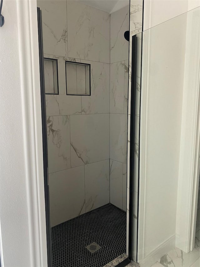 bathroom featuring marble finish floor and a marble finish shower