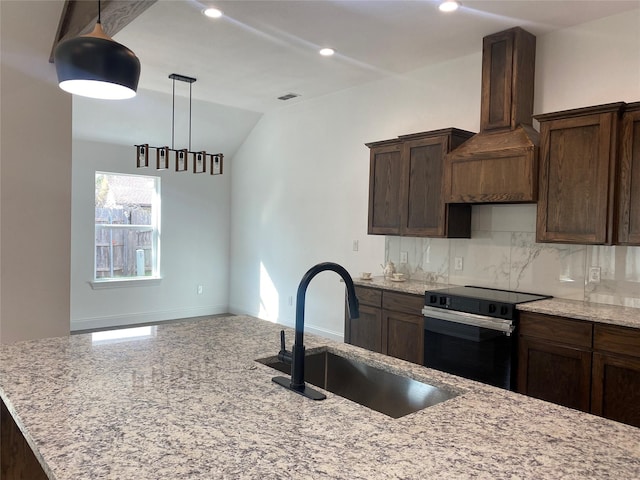 kitchen with custom exhaust hood, hanging light fixtures, electric range, decorative backsplash, and a sink