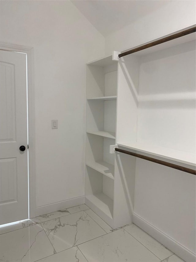 spacious closet featuring marble finish floor