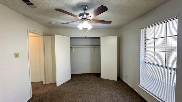 unfurnished bedroom with a textured ceiling, a closet, carpet flooring, and a ceiling fan