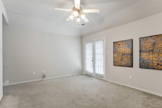 empty room featuring a ceiling fan, visible vents, carpet floors, and baseboards