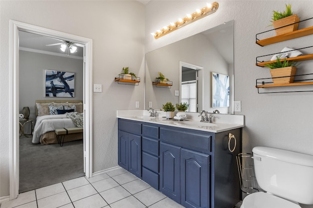 bathroom with a sink, connected bathroom, toilet, and tile patterned floors