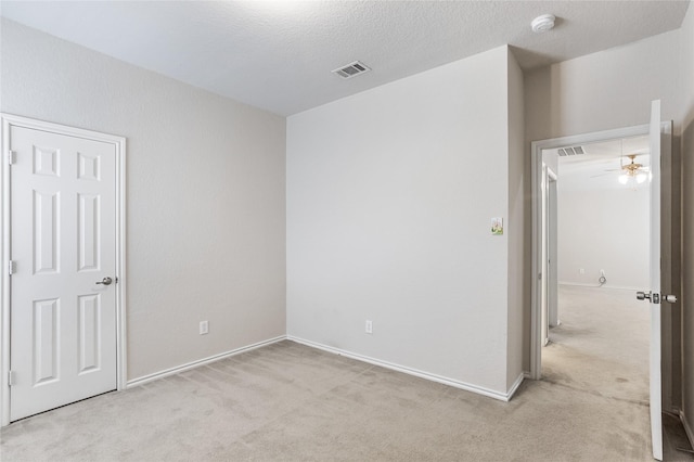 unfurnished bedroom featuring carpet flooring, visible vents, and a textured ceiling