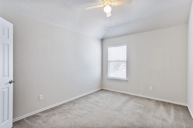 carpeted spare room with baseboards, a ceiling fan, lofted ceiling, and a textured wall