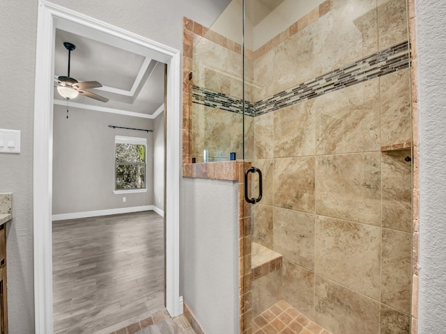 full bath featuring vanity, baseboards, ornamental molding, a tray ceiling, and a stall shower