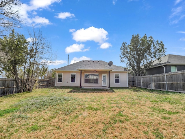 rear view of house featuring a ceiling fan, a patio area, a fenced backyard, and a lawn