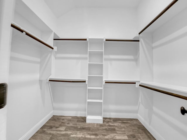 spacious closet with vaulted ceiling and wood finished floors