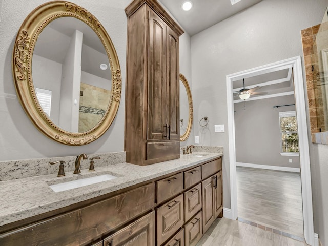 full bath featuring wood finished floors, double vanity, a sink, and ceiling fan