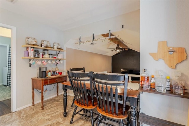 dining room featuring lofted ceiling, ceiling fan, and baseboards