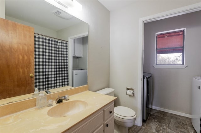 bathroom featuring visible vents, toilet, vanity, independent washer and dryer, and baseboards