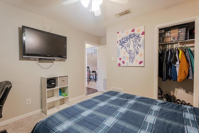 carpeted bedroom with a ceiling fan, a closet, visible vents, and baseboards