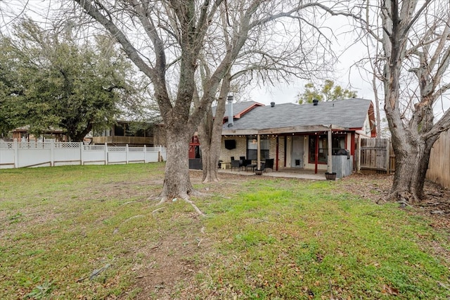 back of property featuring a fenced backyard, a patio, brick siding, and a lawn