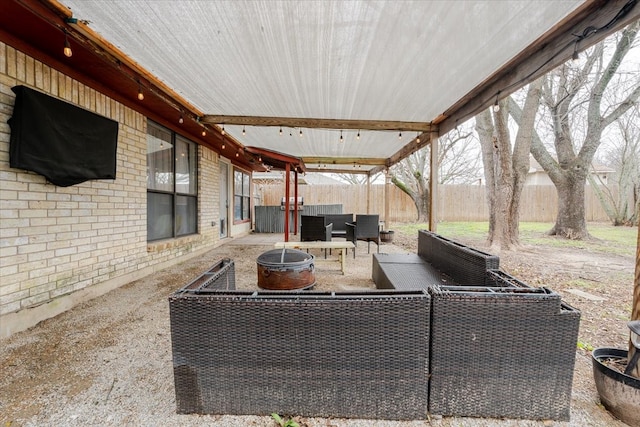 view of patio / terrace with a fenced backyard and an outdoor living space with a fire pit