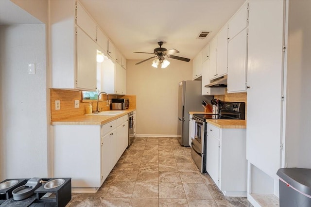 kitchen with visible vents, stainless steel appliances, light countertops, under cabinet range hood, and a sink