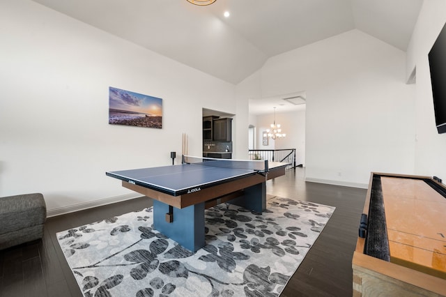 playroom with a chandelier, high vaulted ceiling, dark wood finished floors, and baseboards