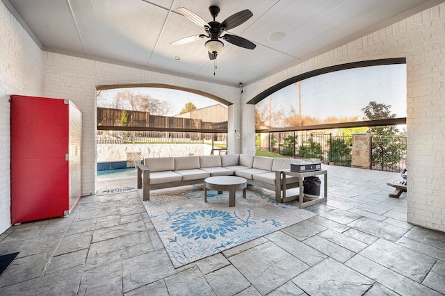 view of patio / terrace featuring fence, an outdoor living space, and a ceiling fan