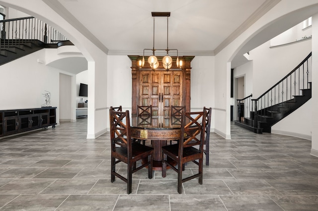 dining room with arched walkways, crown molding, and baseboards