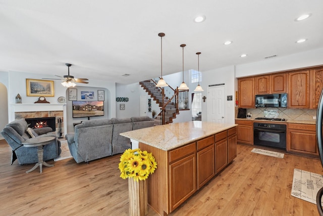 3532 Delaney Dr, Fort Worth, TX 76244 - kitchen featuring black appliances, light wood-type flooring, decorative backsplash, recessed lighting, and a stone fireplace