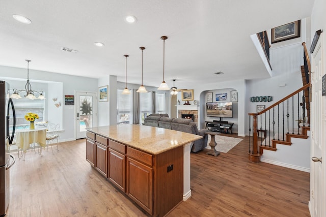 3532 Delaney Dr, Fort Worth, TX 76244 - kitchen with a fireplace, brown cabinets, light wood-style flooring, baseboards, and recessed lighting