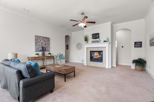 living room with arched walkways, light colored carpet, crown molding, and baseboards