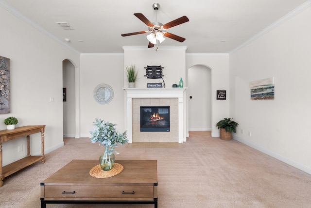 living room with carpet floors, arched walkways, crown molding, and a fireplace