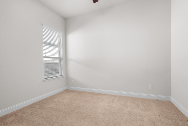 unfurnished room featuring baseboards, a ceiling fan, and light colored carpet