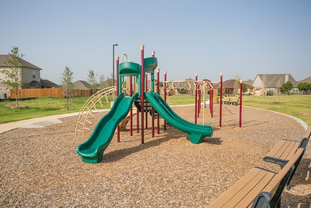 community playground featuring a yard and fence