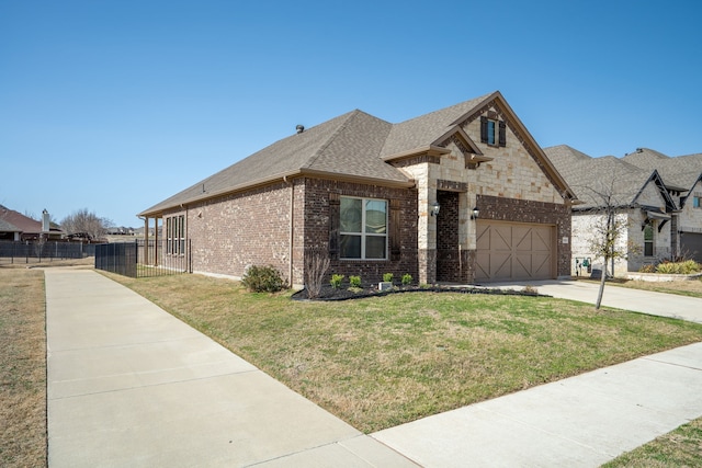 french country inspired facade featuring an attached garage, brick siding, fence, roof with shingles, and a front yard