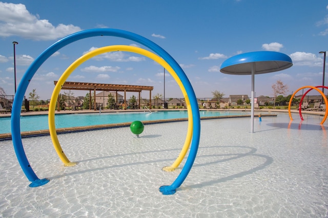 view of playground with fence and a community pool