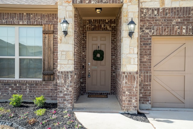 property entrance featuring brick siding and an attached garage