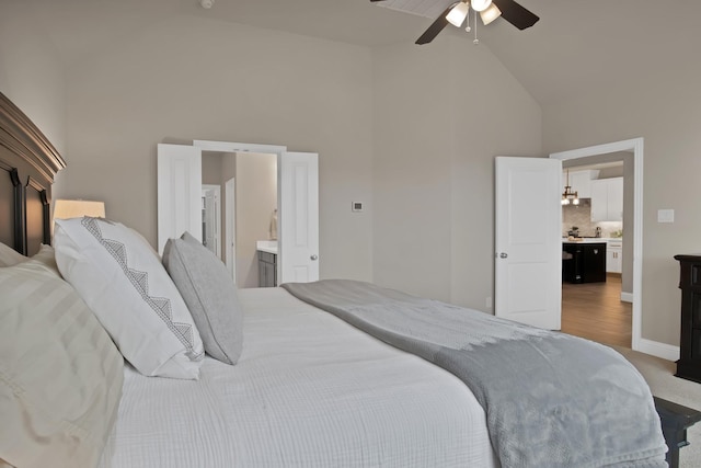 carpeted bedroom featuring high vaulted ceiling, connected bathroom, a ceiling fan, and baseboards