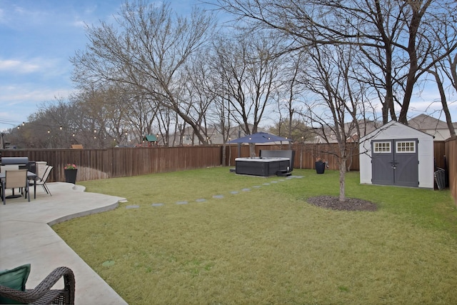 view of yard featuring an outbuilding, a patio, a storage unit, a hot tub, and a fenced backyard