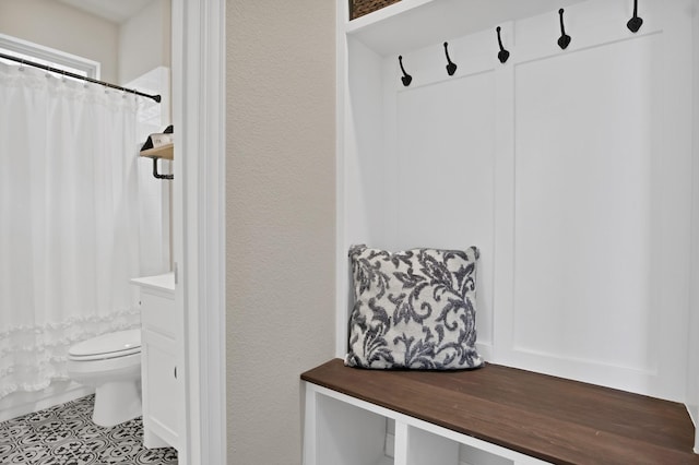 mudroom with tile patterned flooring and a textured wall