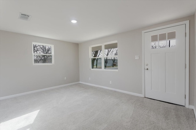 carpeted entryway featuring baseboards, visible vents, and a healthy amount of sunlight