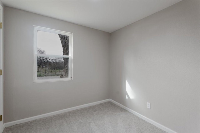 spare room featuring plenty of natural light, baseboards, and carpet flooring