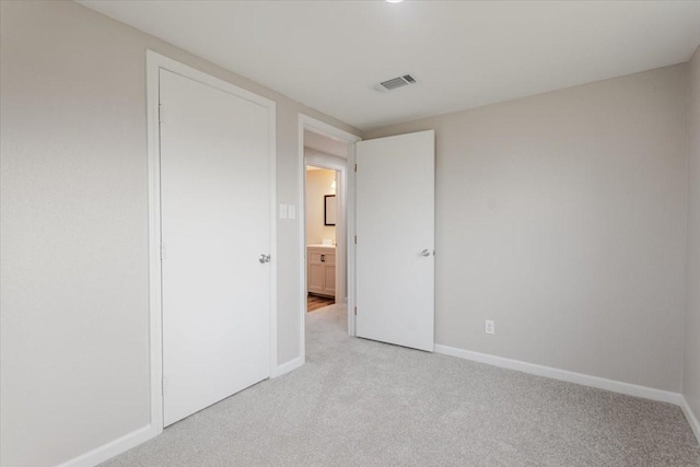 unfurnished bedroom with baseboards, visible vents, and light colored carpet