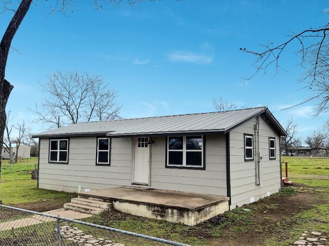 view of front of home featuring metal roof and fence